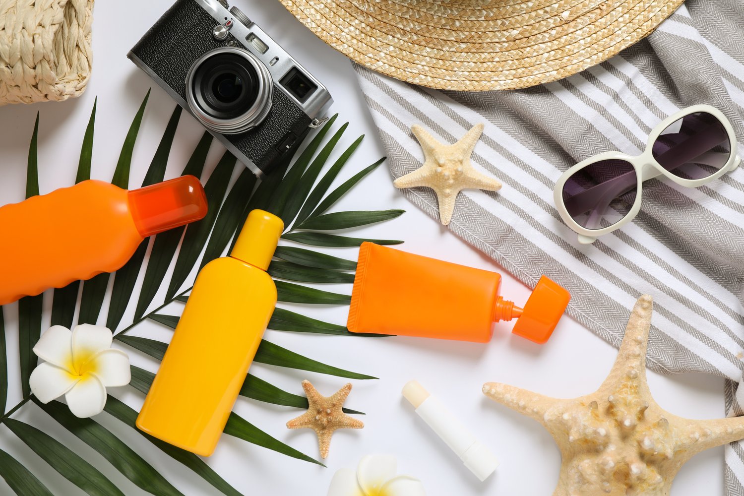  Photo of composition with sun protection products and beach accessories on white background, top view	
