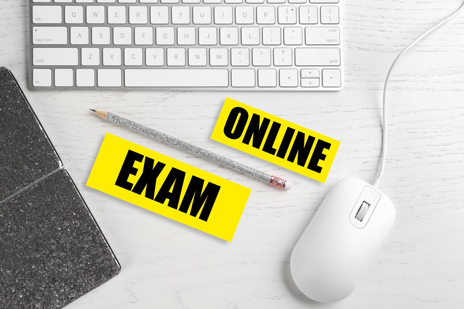 Photo of flat lay composition with mouse, keyboard and phrase ONLINE EXAM on white wooden table
