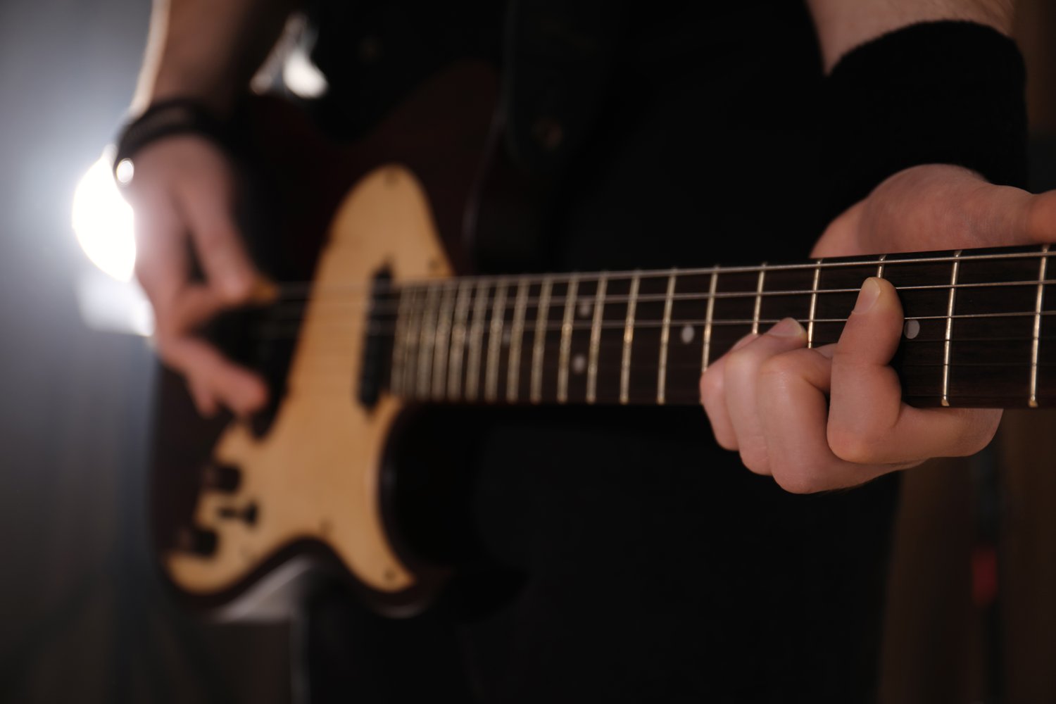 Photo of man playing electric guitar on stage, closeup. Rock music