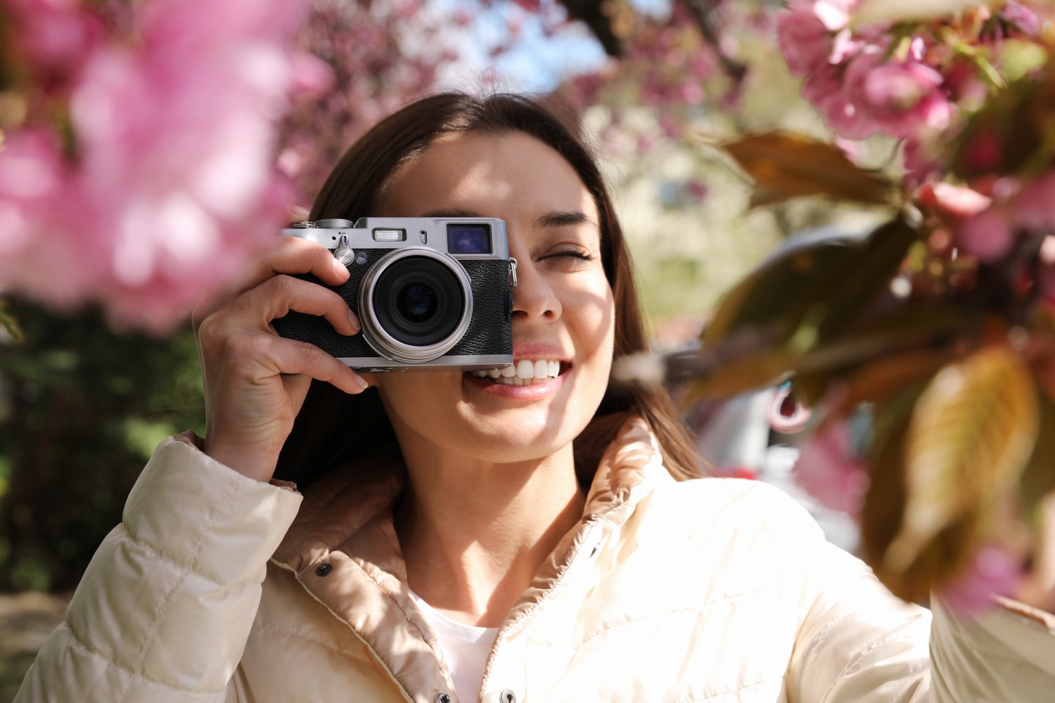 Photo of happy female tourist taking photo of nature outdoors on spring day