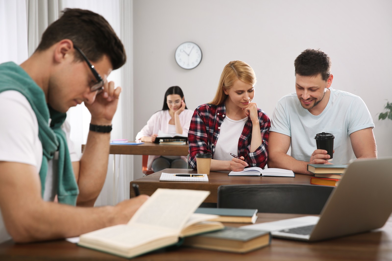 Photo of students reading books and studying in library