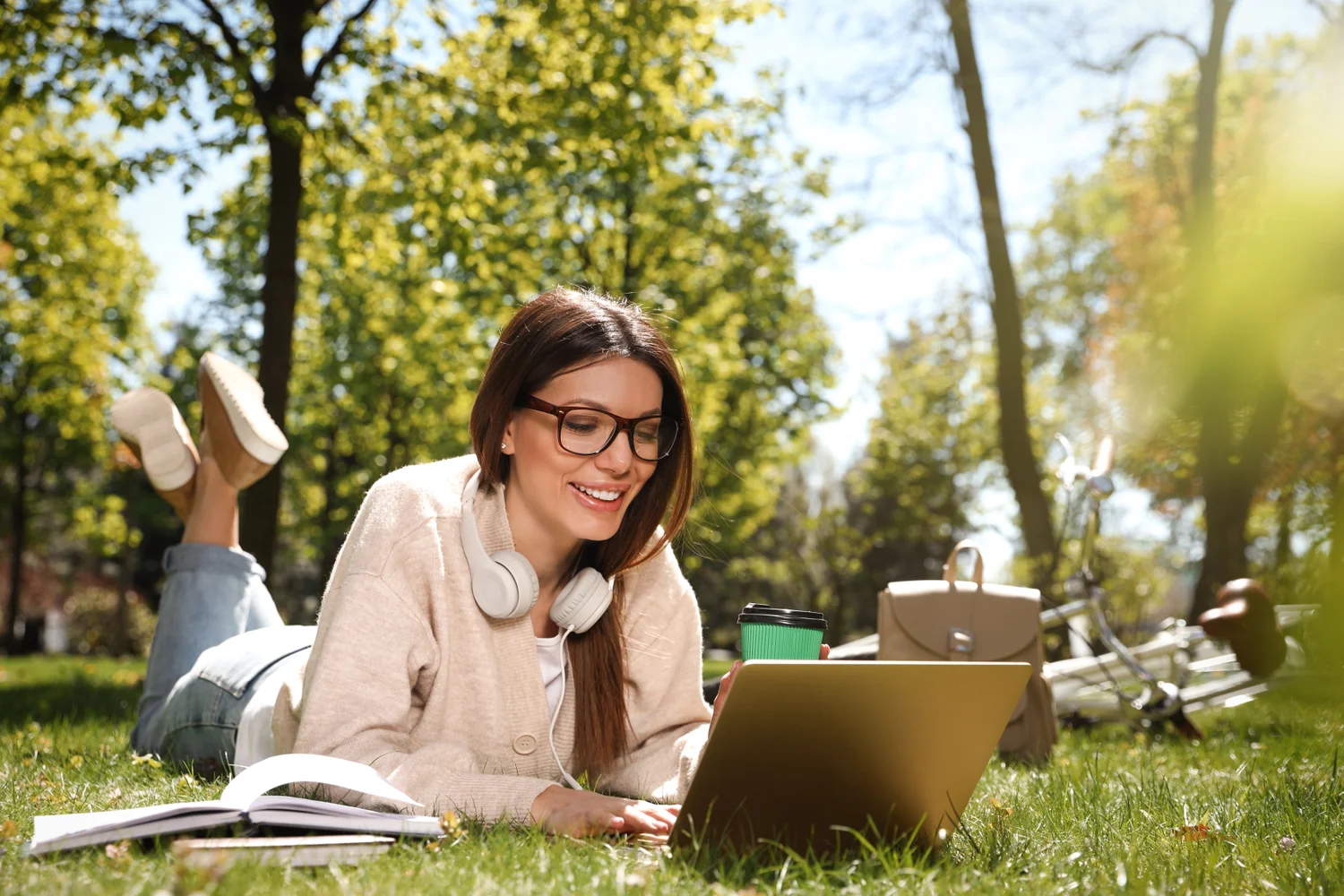 Photo of beautiful woman working with laptop in park