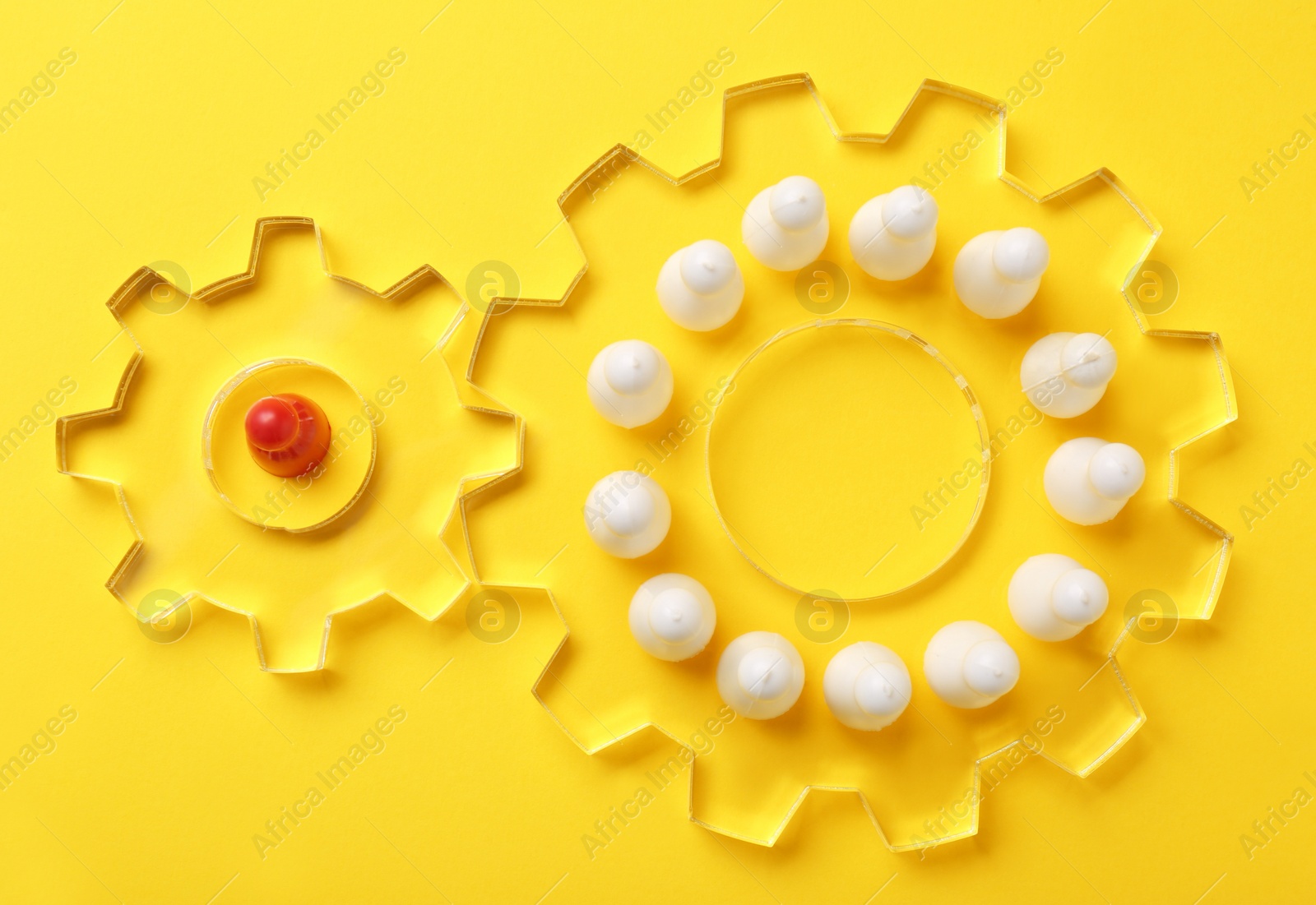 Photo of Employee selection process. Flat lay composition with cogwheels, red pawn as recruiter and white ones as applicants on yellow background