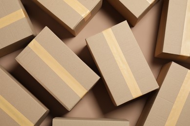 Photo of Many cardboard boxes on light brown background, flat lay