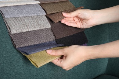 Photo of Woman choosing fabric among colorful samples on green sofa, closeup