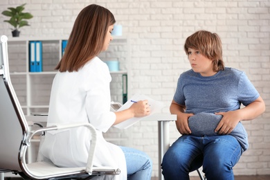 Photo of Overweight boy consulting with doctor in clinic