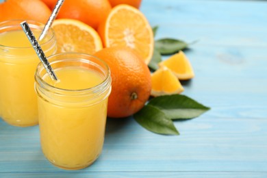 Photo of Delicious orange juice and fresh fruits on light blue wooden table. Space for text