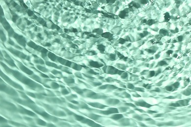 Image of Rippled surface of clear water on aquamarine background, closeup
