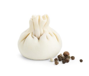 Photo of Uncooked khinkali (dumpling) and peppercorns isolated on white. Georgian cuisine