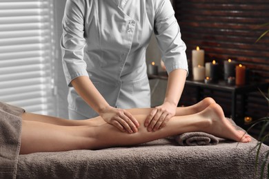 Photo of Woman receiving leg massage in spa salon, closeup