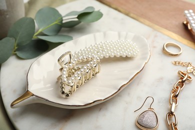 Photo of Stylish bijouterie and hair accessories on decorative board, closeup