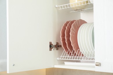 Photo of Clean plates on shelf in cabinet indoors