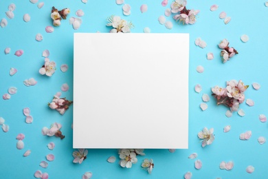 Photo of Flat lay composition with fresh spring flowers and blank card on color background, space for text