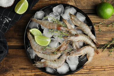 Photo of Flat lay composition with raw shrimps on wooden table