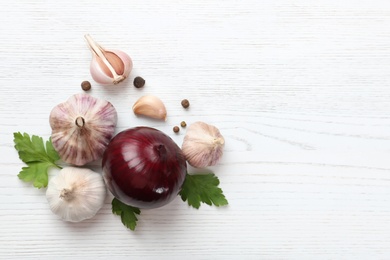 Photo of Composition with garlic, parsley and onion on white wooden background, top view. Space for text