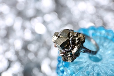 Photo of Beautiful silver ring with pyrite gemstones on blurred background, closeup. Space for text