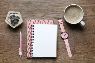 Photo of Flat lay composition with office stationery and cup of coffee on wooden table. Space for design