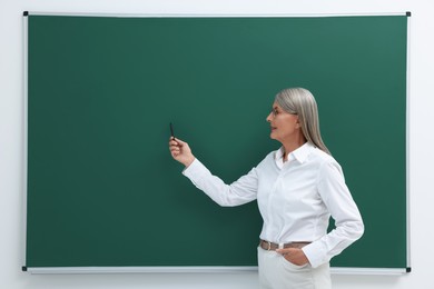 Photo of Professor explaining something at blackboard indoors, space for text