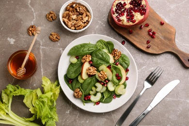 Photo of Delicious fresh celery salad served on grey table, flat lay
