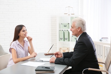 Photo of Young woman having meeting with lawyer in office