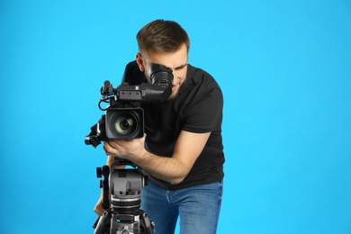 Photo of Operator with professional video camera on blue background