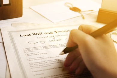 Image of Woman reading Last Will and Testament at table, closeup