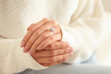 Photo of Young woman wearing beautiful engagement ring, closeup