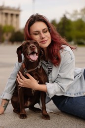 Photo of Woman with her cute German Shorthaired Pointer dog outdoors