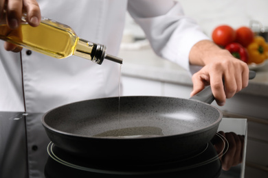 Photo of Man pouring cooking oil from bottle into frying pan, closeup
