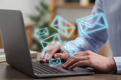 Image of Man typing on laptop at table indoors, closeup. Many illustrations of envelope as incoming messages out of device