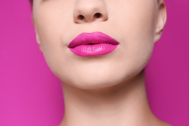 Photo of Beautiful young woman with perfect lips makeup on color background, closeup