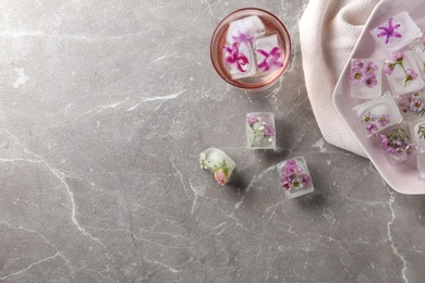 Photo of Flat lay composition with floral ice cubes on table. Space for text