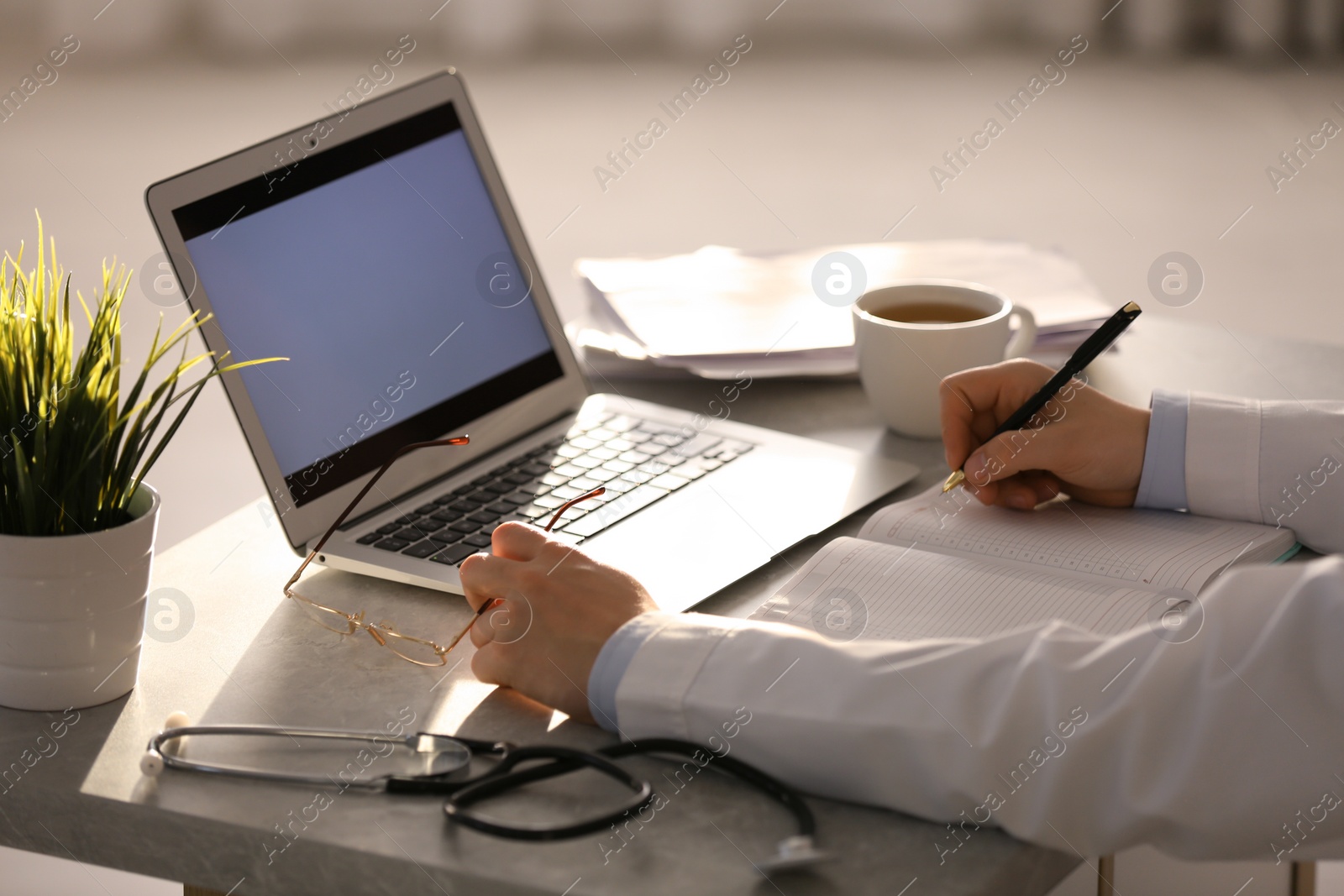 Photo of Professional doctor with laptop working in office, closeup