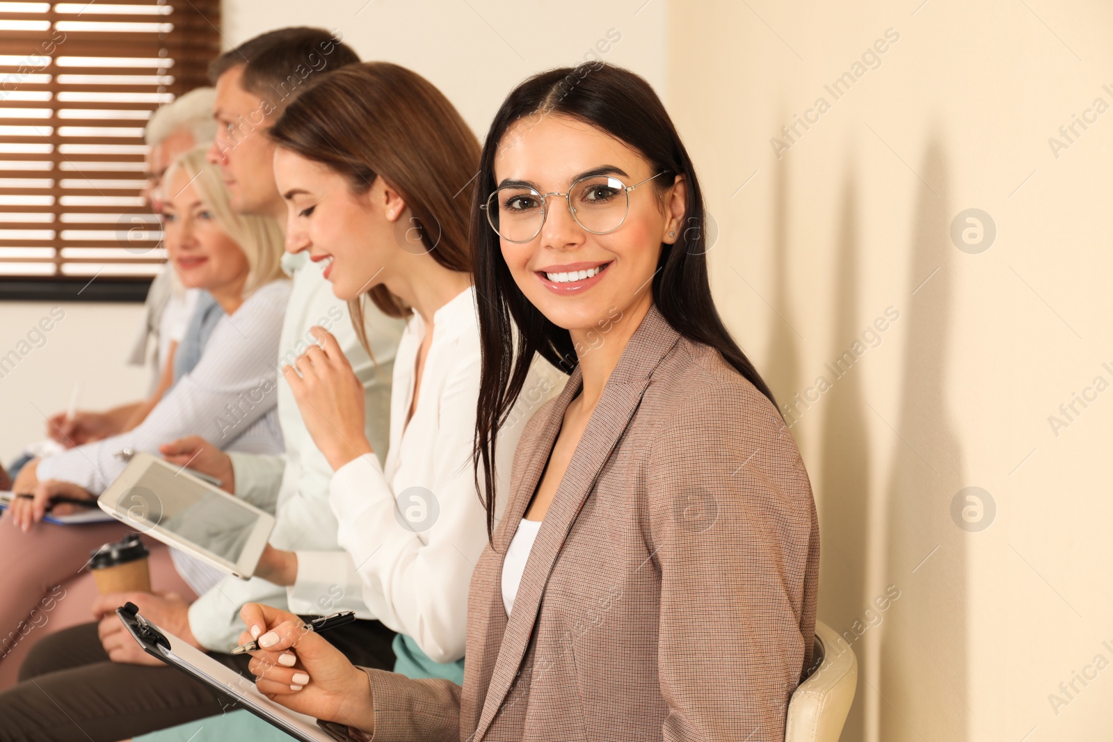 Photo of Woman with clipboard waiting for job interview in office