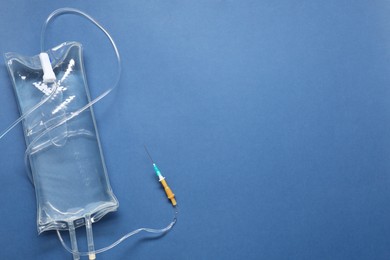Photo of IV infusion set on blue background, top view. Space for text