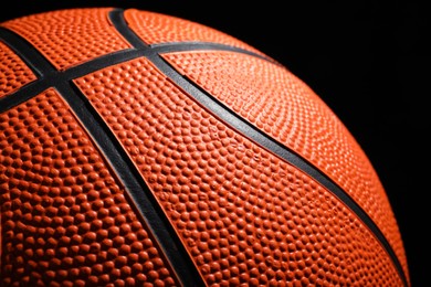 Photo of Orange basketball ball on black background, closeup