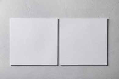 Photo of Blank paper sheets on grey textured background, top view. Mockup for design