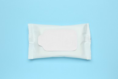 Photo of Wet wipes flow pack on light blue background, top view