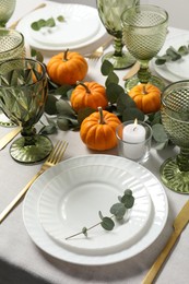 Photo of Beautiful autumn table setting. Plates, cutlery, glasses, pumpkins and floral decor