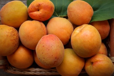 Photo of Basket with delicious ripe apricots, top view