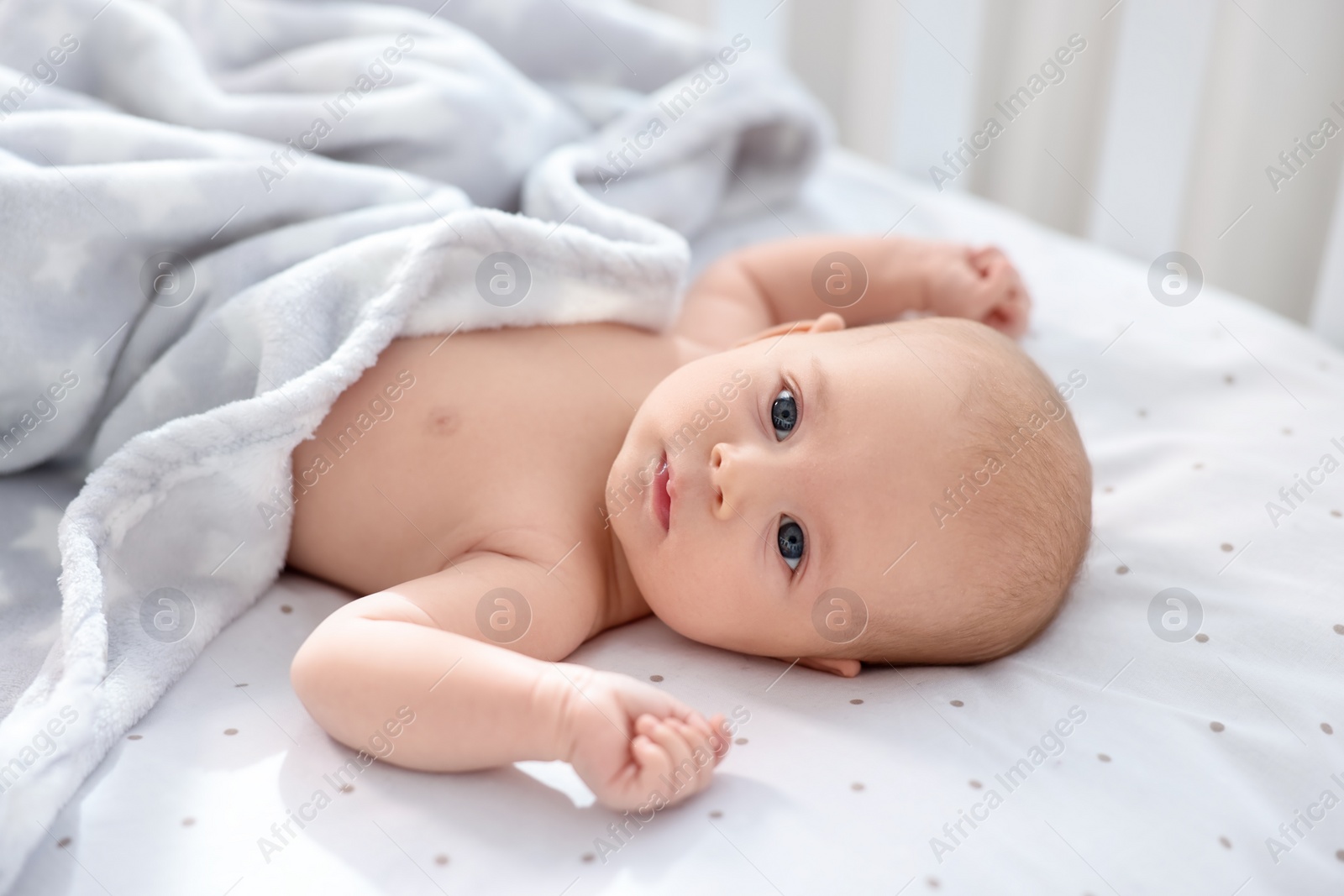 Photo of Cute little baby lying in crib at home