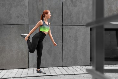Photo of Beautiful woman in gym clothes doing exercises on street