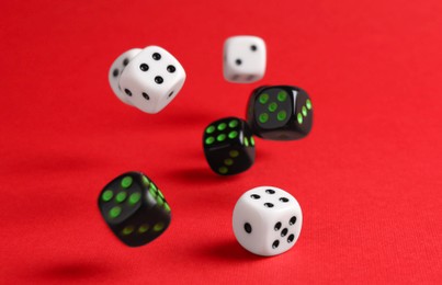 Photo of Many color game dices falling on red background. Space for text