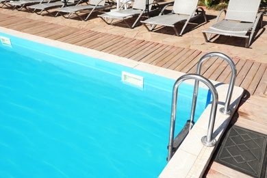 Photo of Modern swimming pool with step ladder outdoors