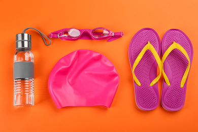 Photo of Flat lay composition with swimming accessories on orange background