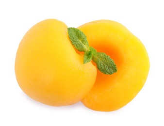 Photo of Sweet canned peach halves with mint isolated on white, top view