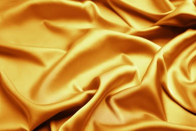 Image of Delicate golden silk fabric as background, closeup view