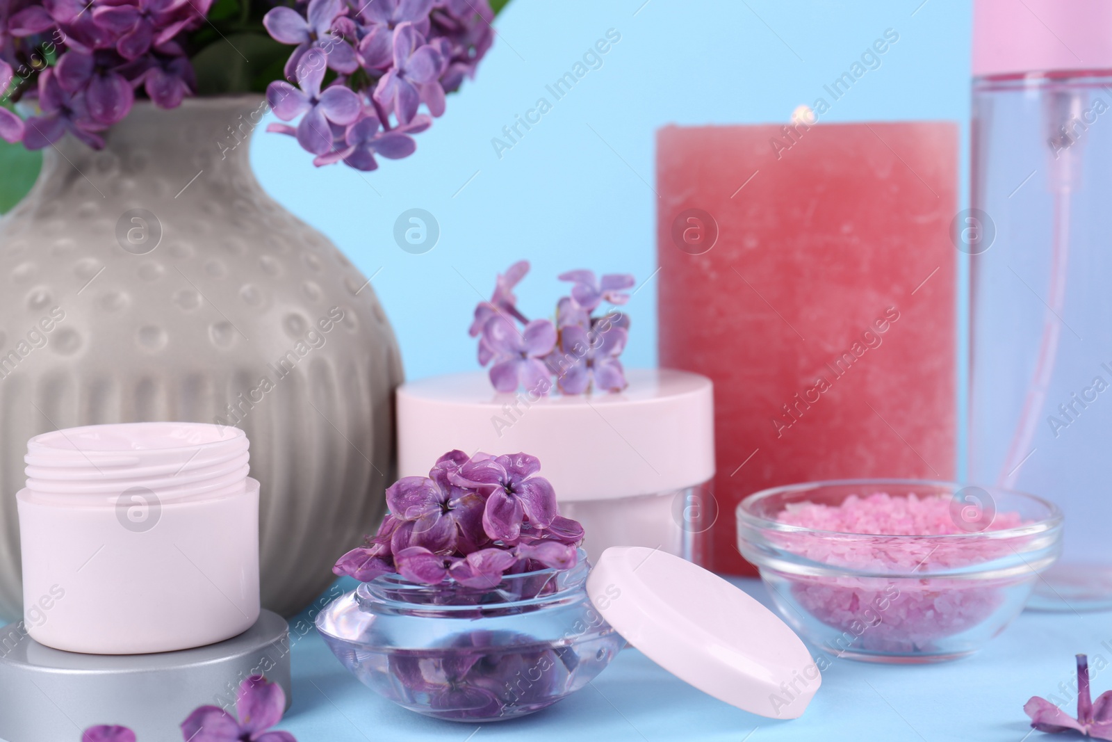 Cosmetic products and lilac flowers on light blue background, closeup Photo of Cosmetic products and lilac flowers on light blue background, closeup