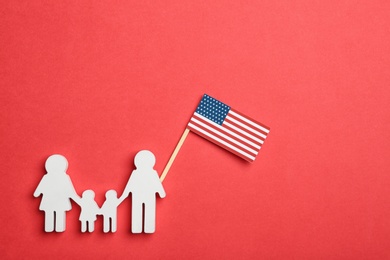 Photo of Flat lay composition of family figure with USA flag on color background. Happy Independence Day