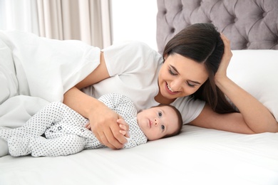 Photo of Happy woman with her cute baby on bed